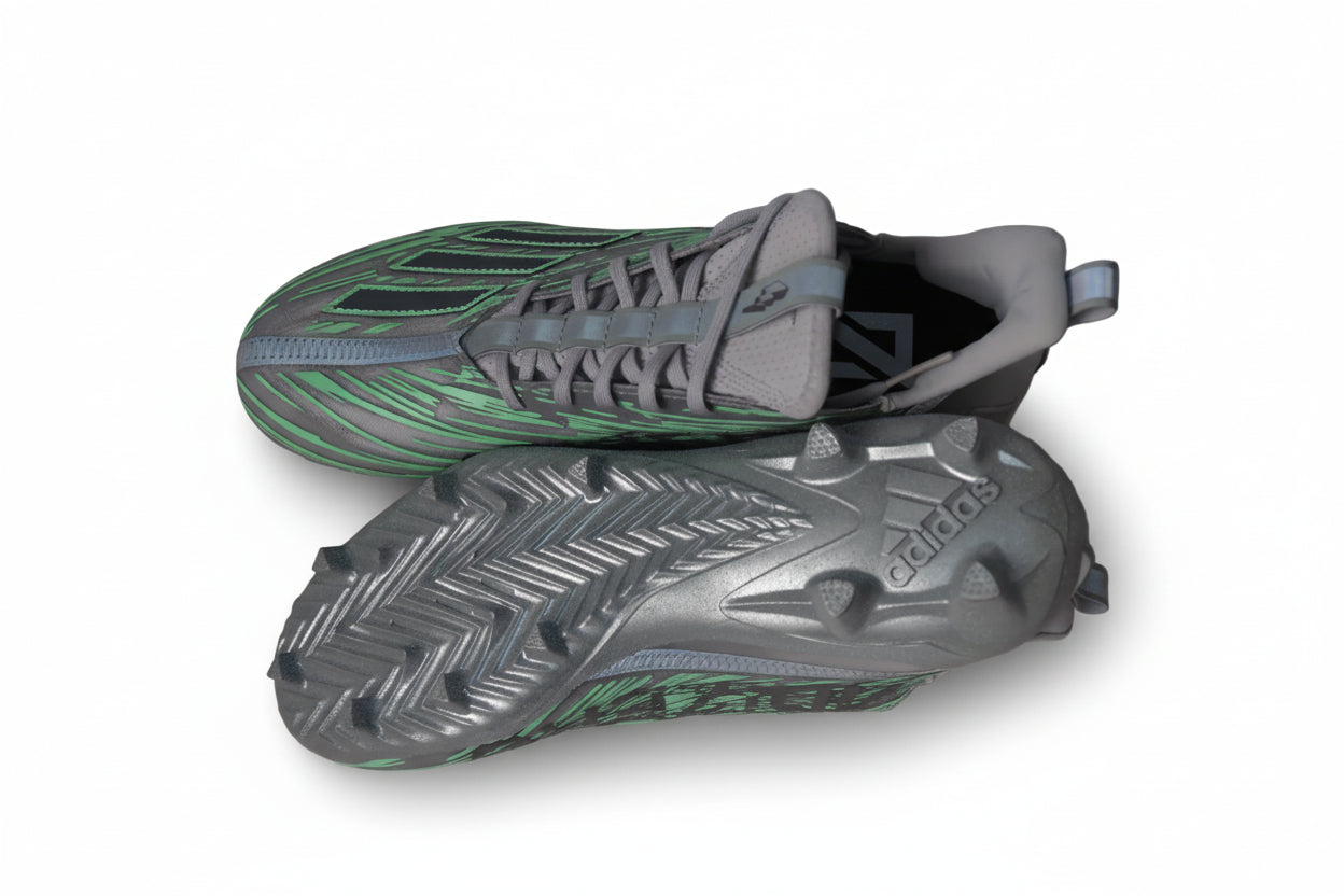 Top and bottom view of Adidas Adizero Flash football cleats in silver and green, showing the upper design and traction pattern on a light gray background.